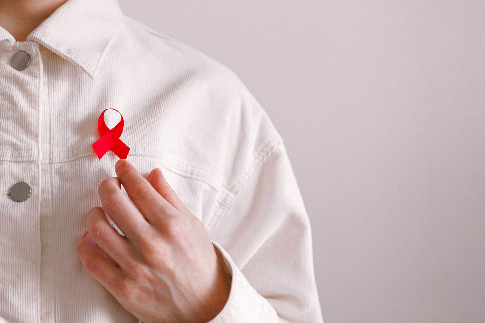 Mand med et rødt bånd på trøjen på World AIDS Day